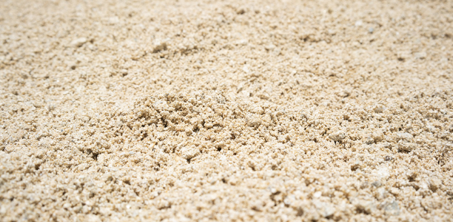 Silica sand - A photo of fine-grained sand composed of silica particles, a common type of sand found in various natural environments. The photo shows a close-up of the sand, which appears light-colored and has a smooth texture. Silica sand is composed of silicon dioxide (SiO2)